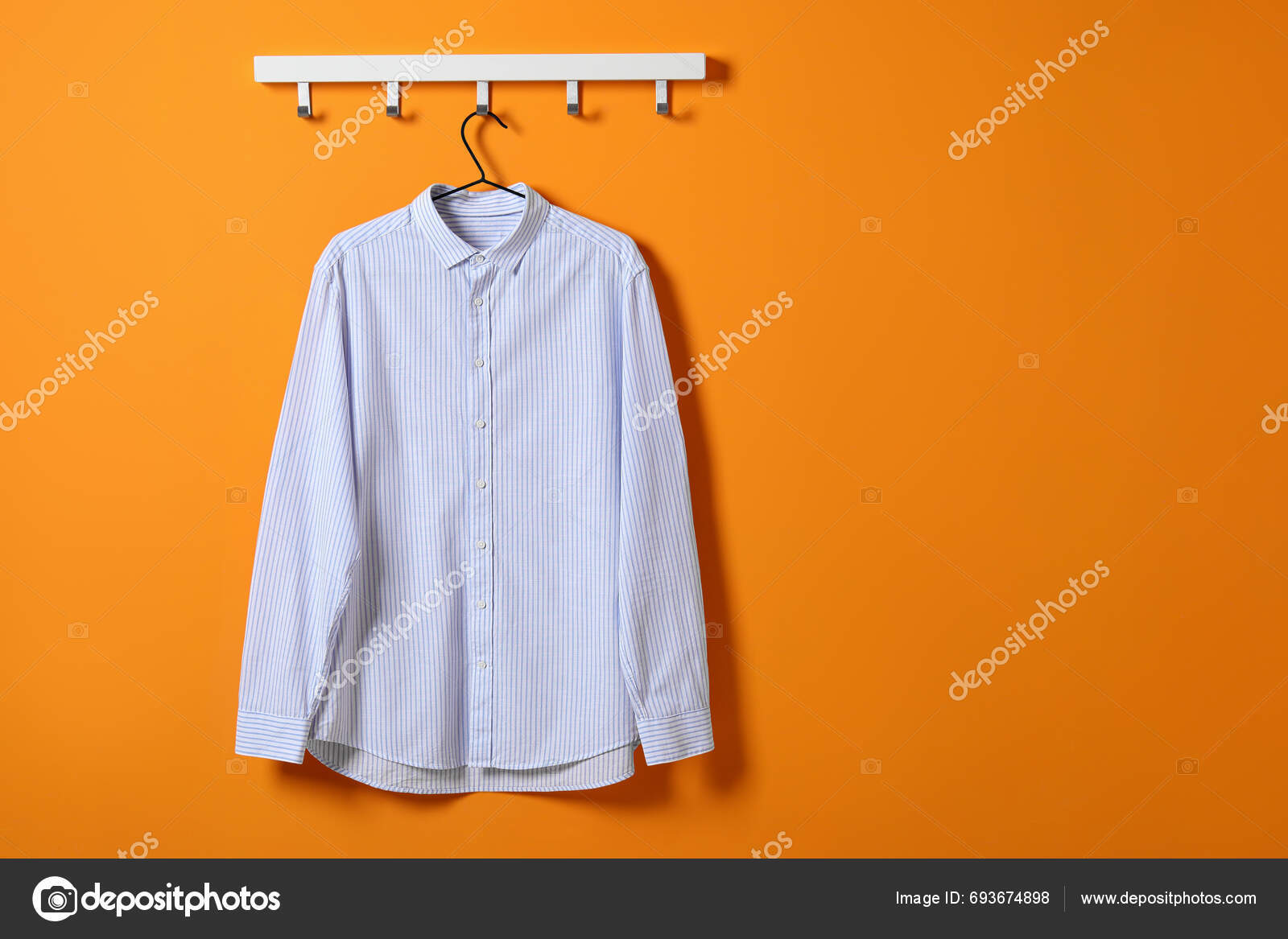depositphotos_693674898-stock-photo-hanger-striped-shirt-orange-wall